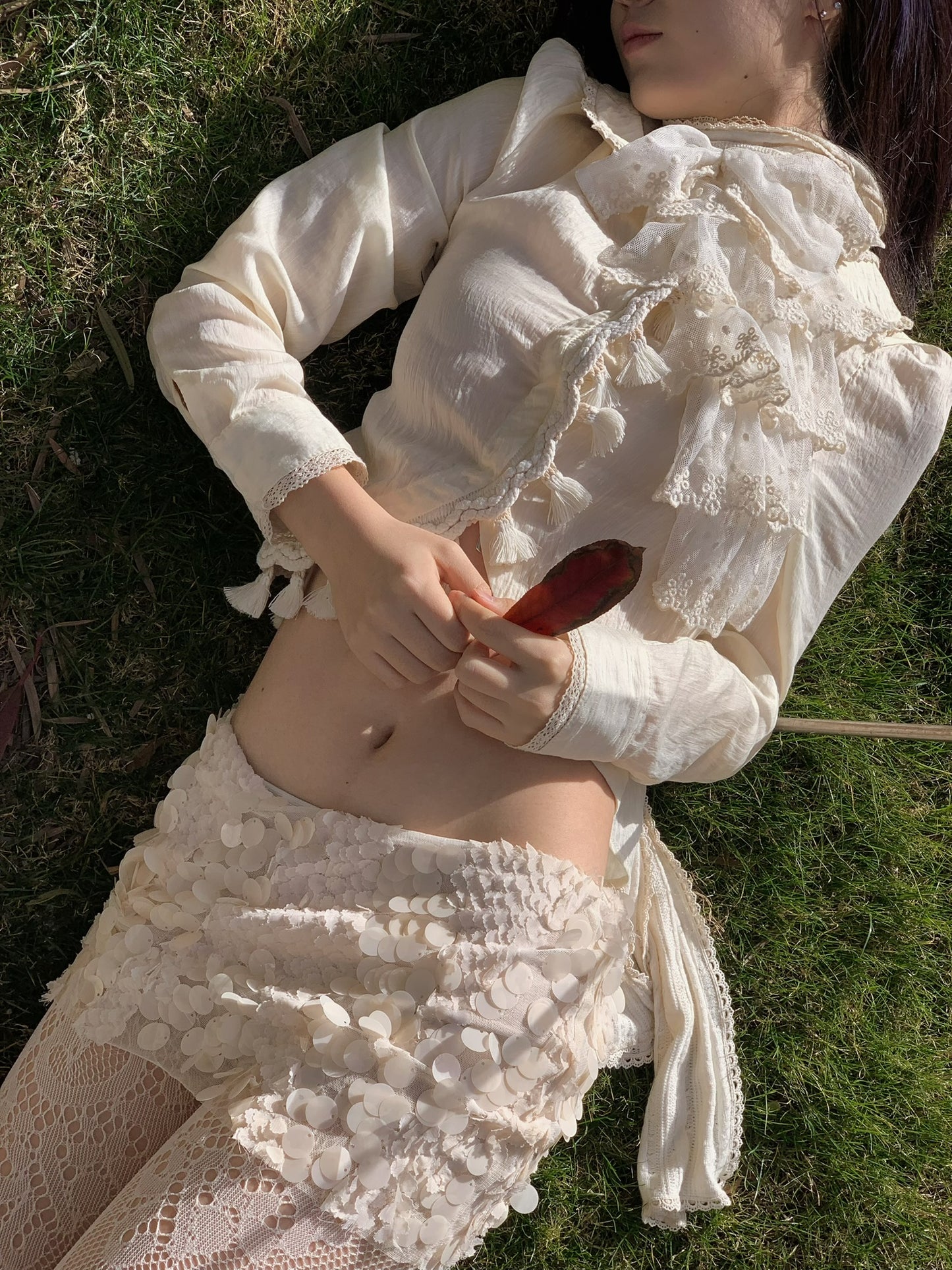 Beige doll shirt with a ruffled collar, lace tassels and an asymmetrical design