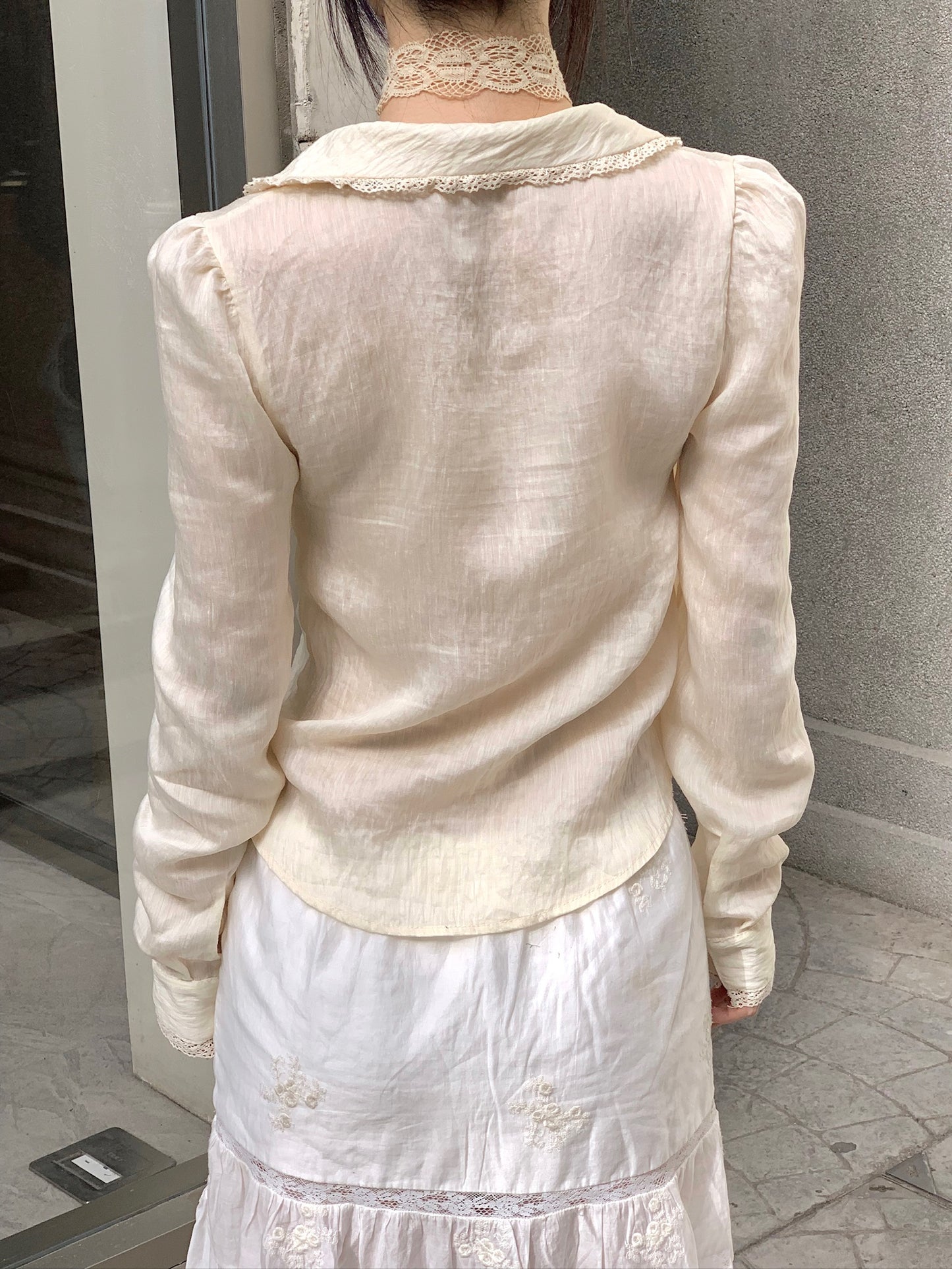 Beige doll shirt with a ruffled collar, lace tassels and an asymmetrical design