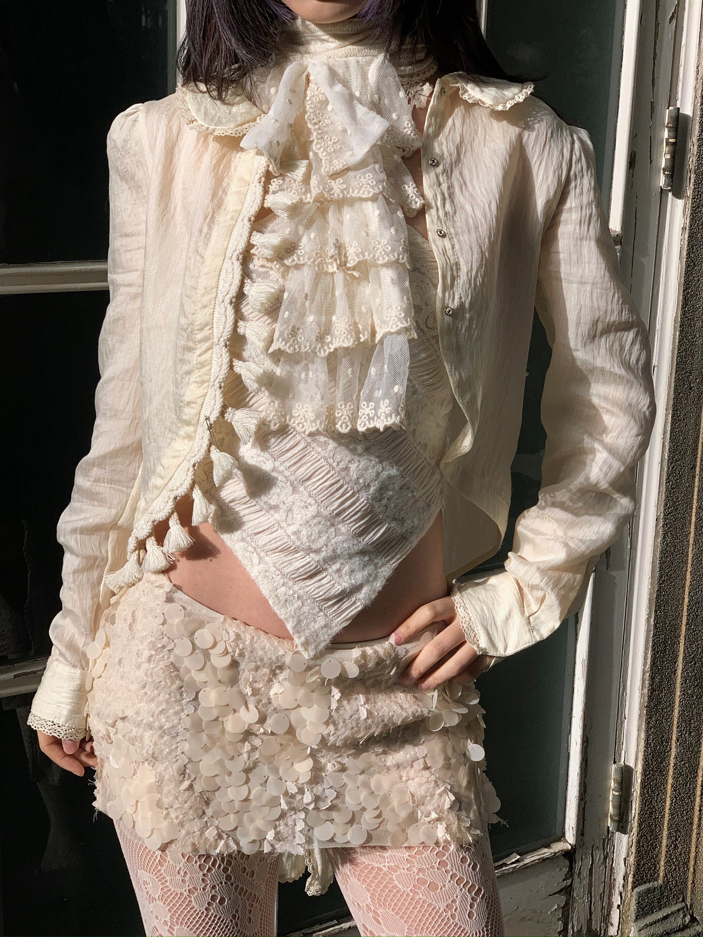 Beige doll shirt with a ruffled collar, lace tassels and an asymmetrical design