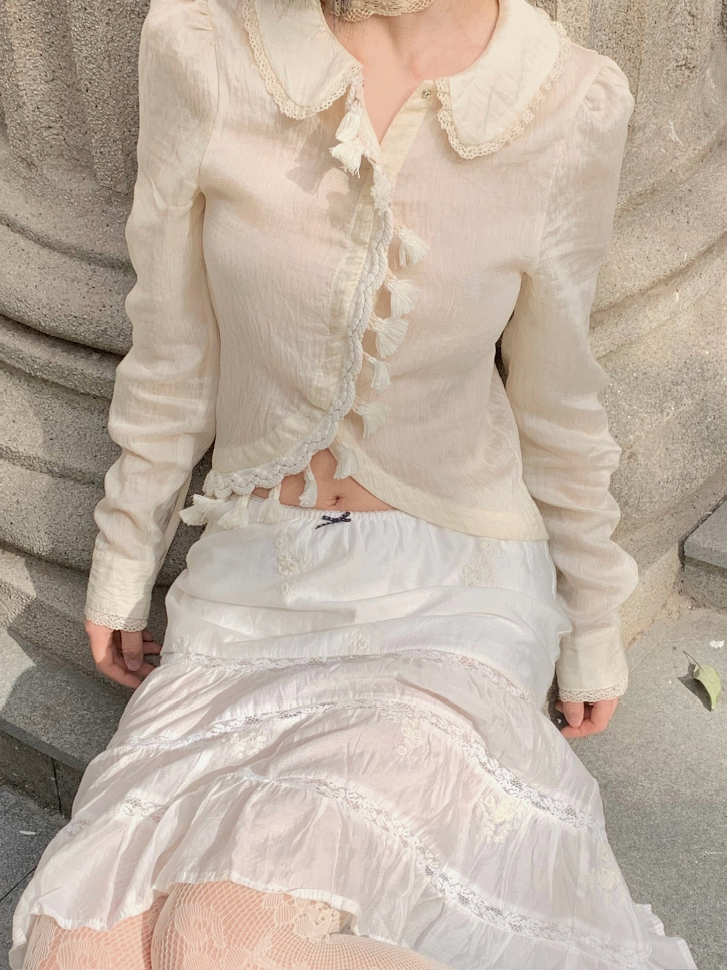 Beige doll shirt with a ruffled collar, lace tassels and an asymmetrical design